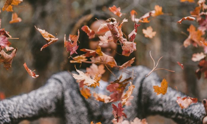 girl throwing leaves