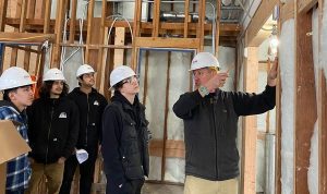 Construction teacher showing students a construction project