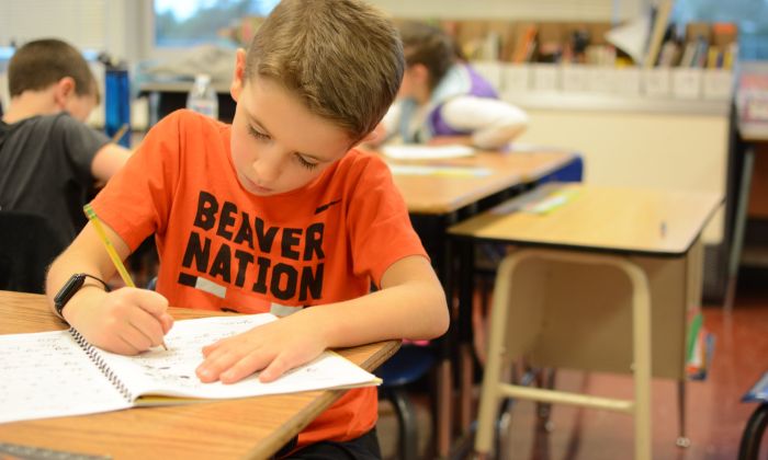 Student writing at desk