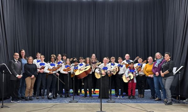 School board members standing on a stage with students from Linus Pauling's Mariachi Band