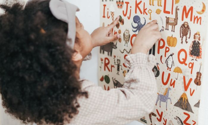 Girl pointing to alphabet